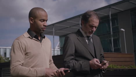 Serious-businessmen-walking-and-using-smartphones
